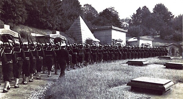 The funeral procession proceeding up Green-Wood's Sycamore Avenue, with the vents of the circa 1850 Receiving Tomb visible at right.