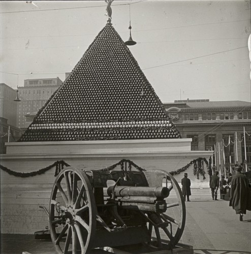 This is quite a visual--what appears to be a pyramid built of artillery shells, with a gun in the foreground.