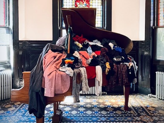 grand piano filled with clothing