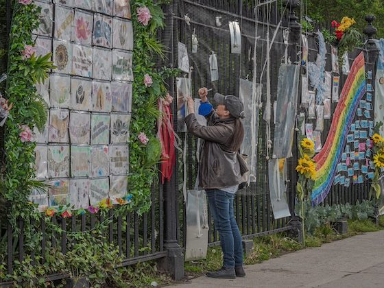 person at fence memorial installation