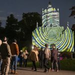 spectators watch projection on historic chapel