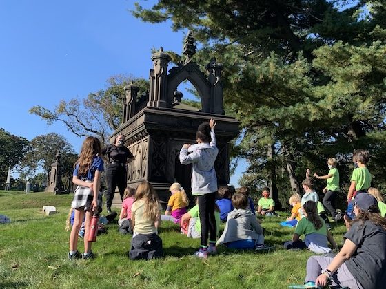 children and teacher at monument